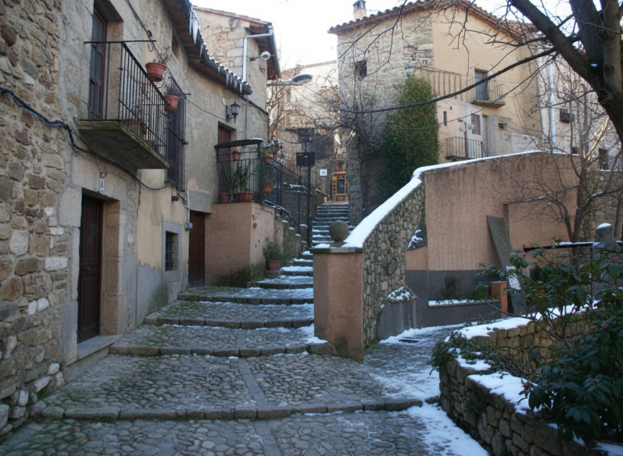 Steep, cobbled alleyway and steps in a quiet, traditional European-style village with old stone buildings and light snow.